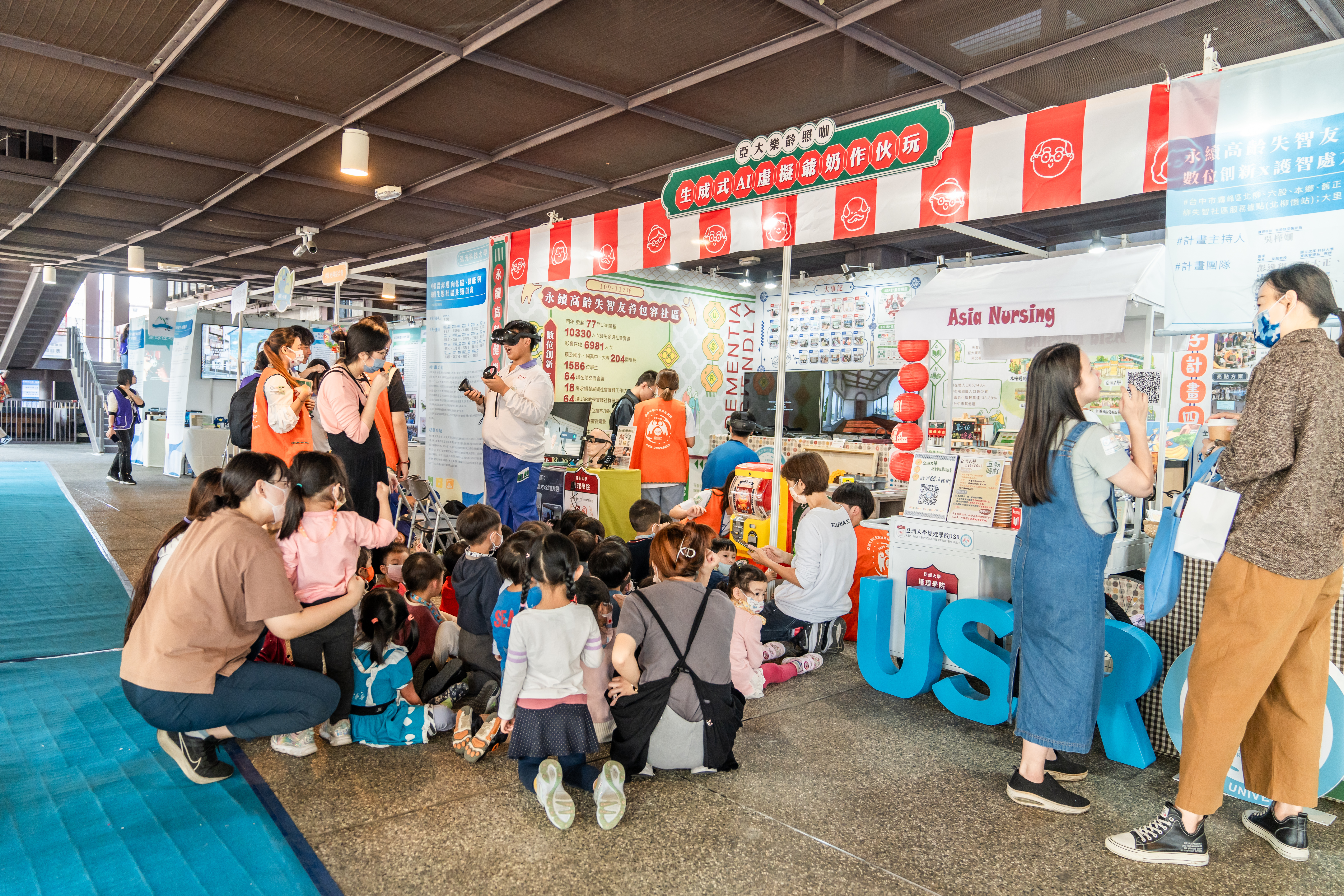 圖為亞大護理學院以「亞大樂齡照咖 生成式AI虛擬爺奶作伙玩」為佈展主題，展示生成式AI、元宇宙應用於高齡失智照顧的成果，十分吸睛。