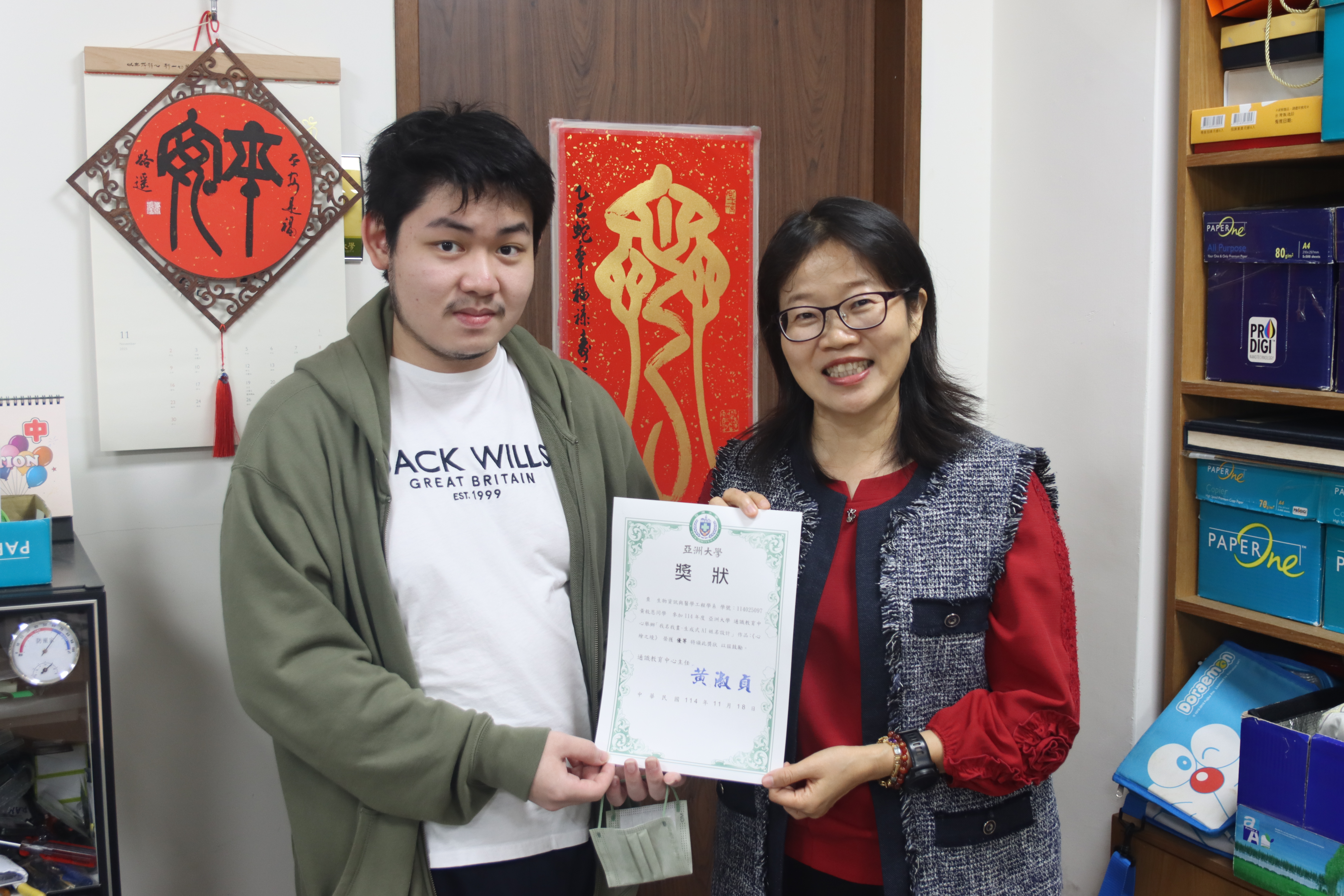 亞大通識教育中心主任黃淑貞(右)，與「我名我畫」優等得獎者生醫系黃敘恩同學(左)合影。