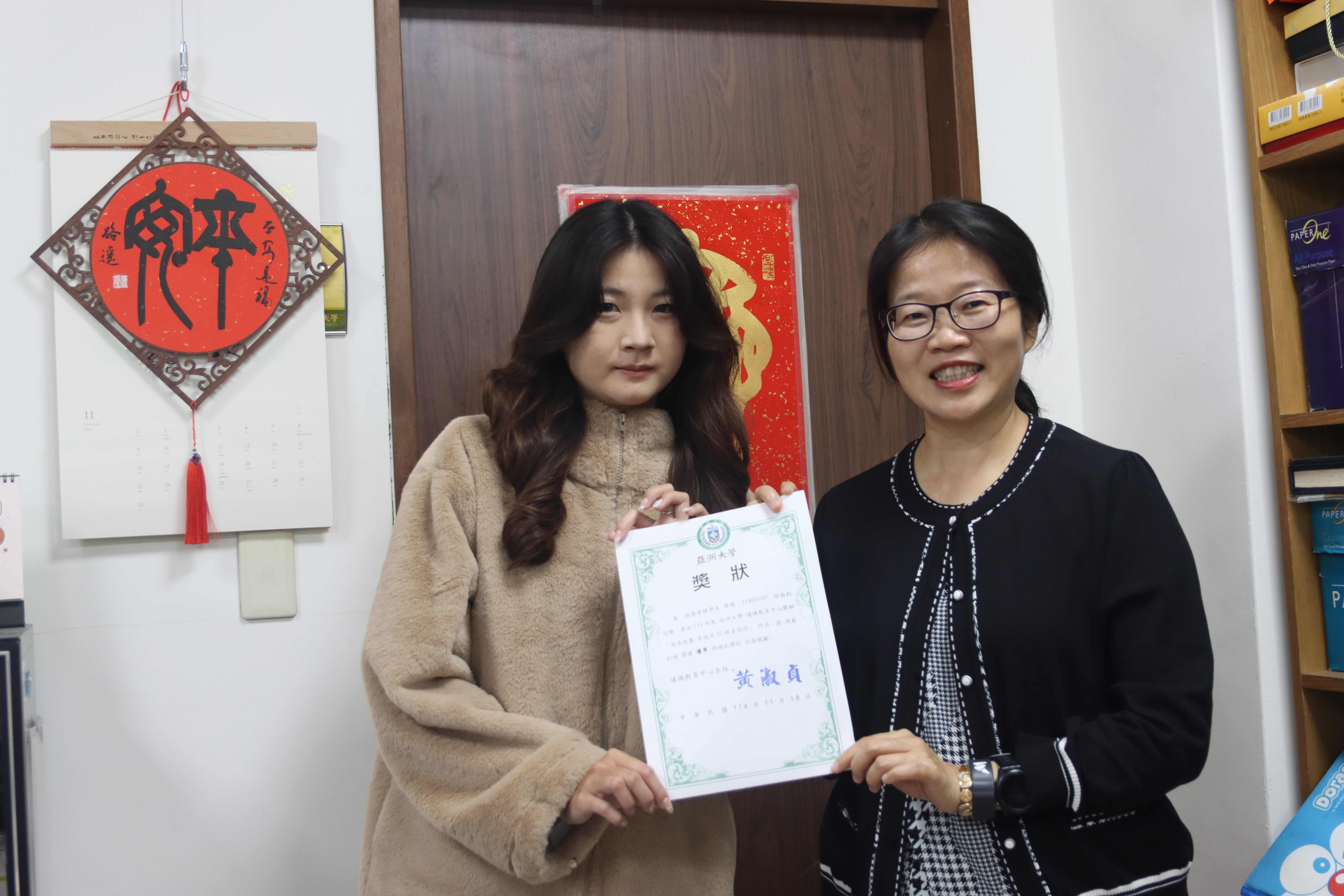 亞大通識教育中心主任黃淑貞(右)，與「我名我畫」優等得獎者經管系徐渝鈞同學(左)合影。