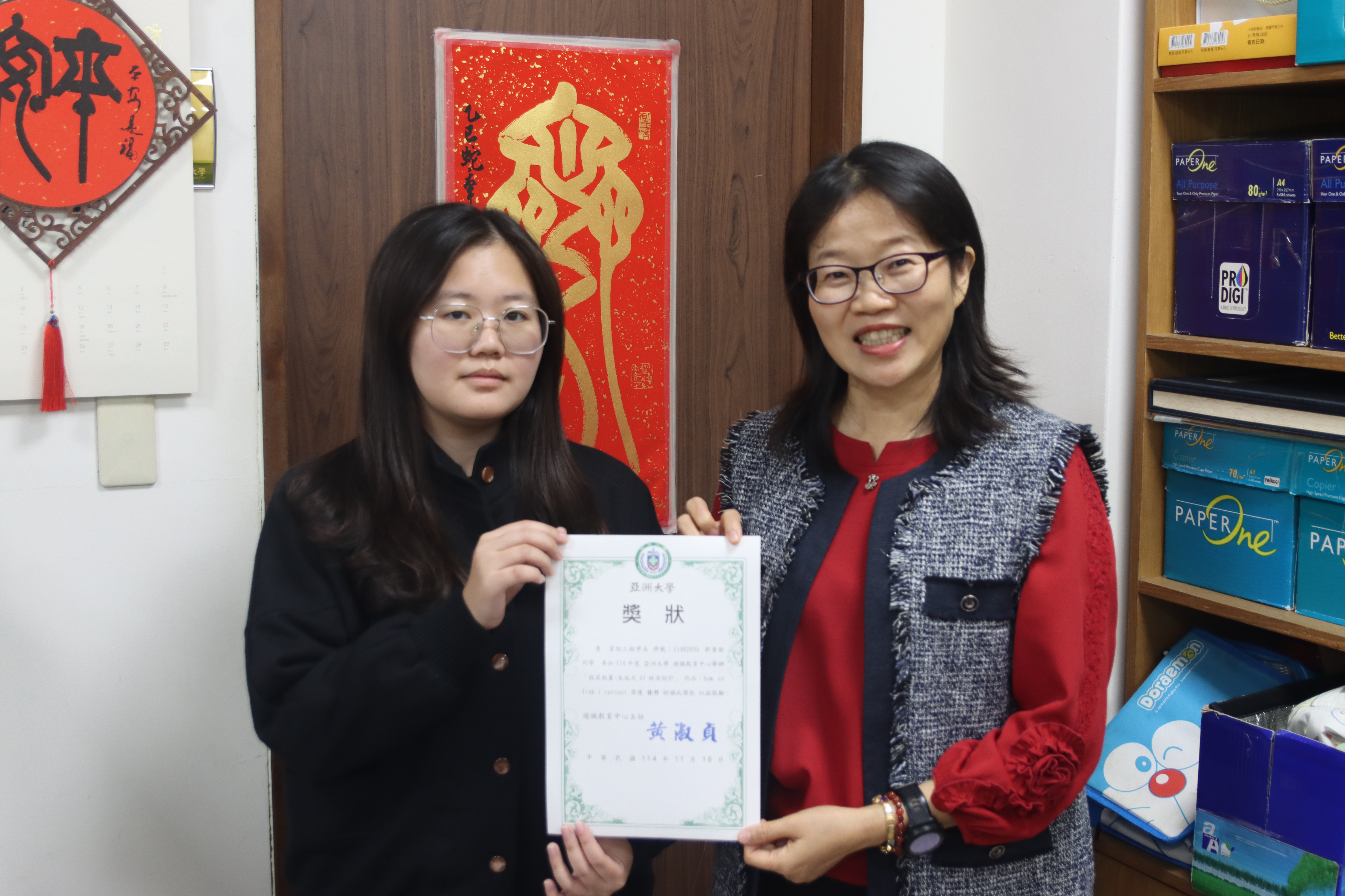 亞大通識教育中心主任黃淑貞(右)，與「我名我畫」優等得獎者資工系郭香愉同學(左)合影。