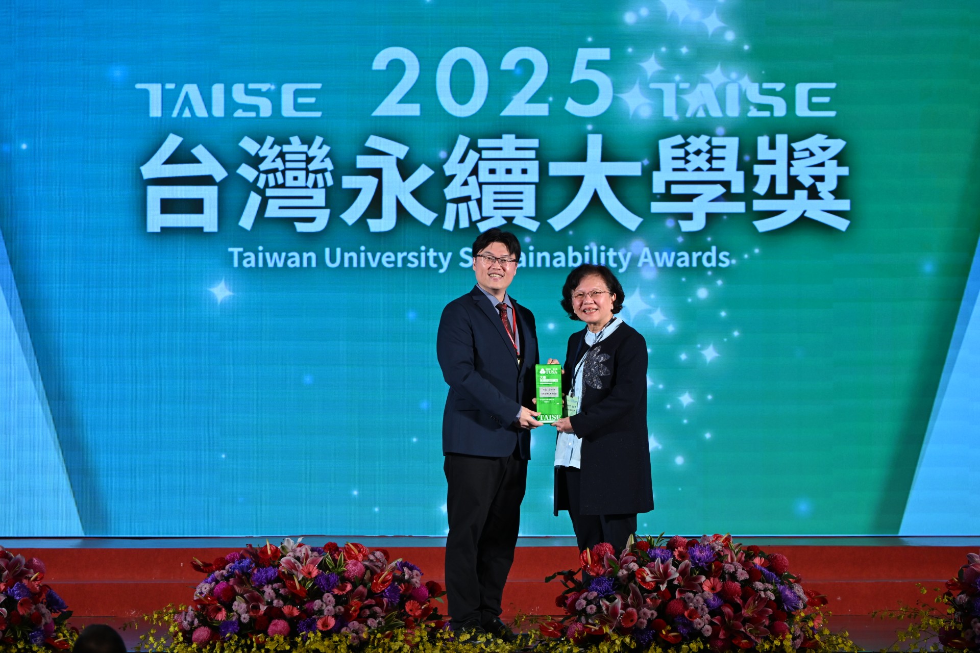 亞大獲「台灣永續績優大學獎」、「永續報告書銀級獎」雙獎，由教育部常務次長朱俊彰(左)頒獎，亞大副校長兼永續長蔡秀芬（右）代表受獎 。