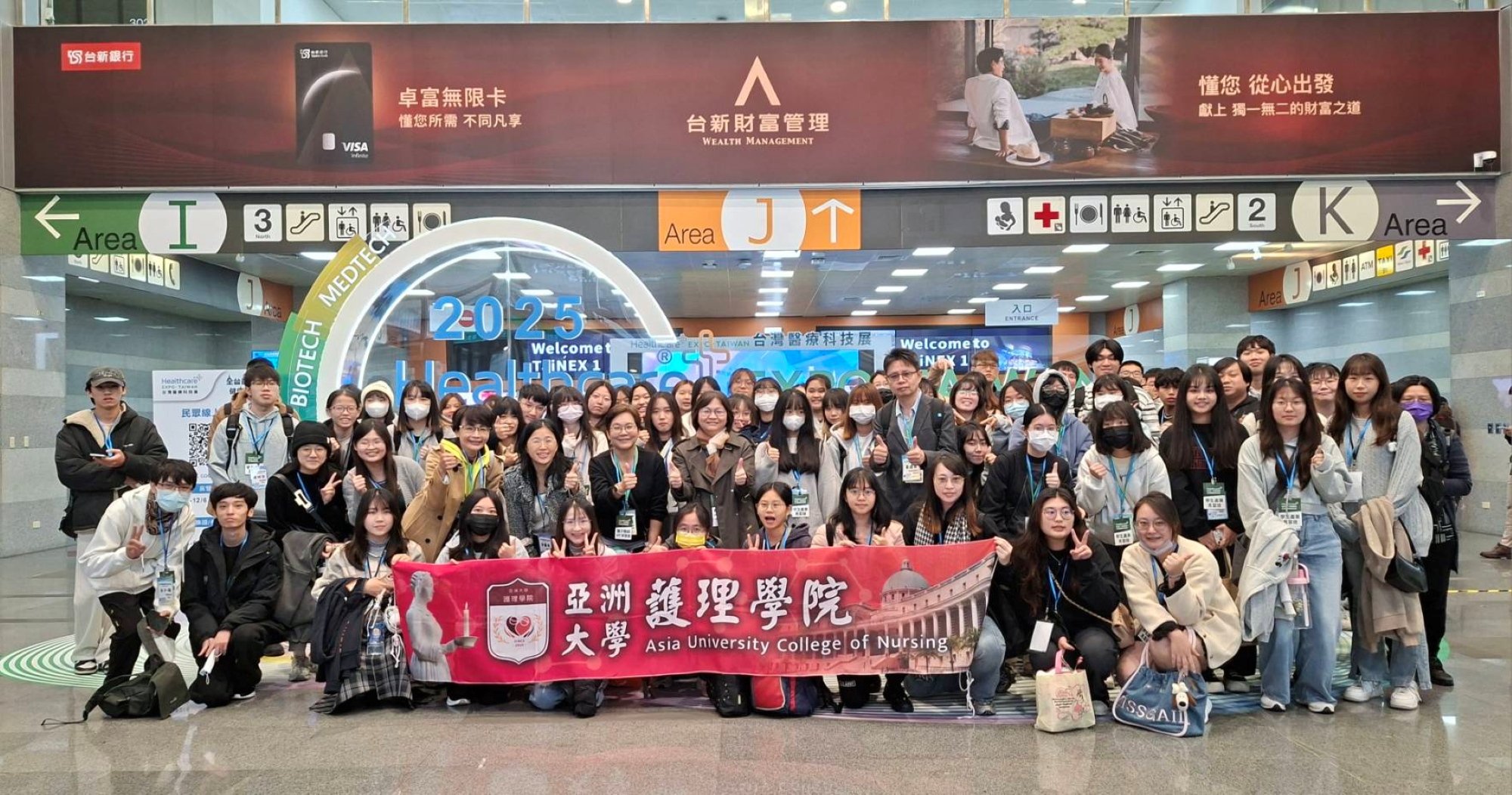 四、 亞洲大學護理學院護理學系、長期照護學系、後護系80位師生於2025台灣醫療科技展場館入口處合影留念。