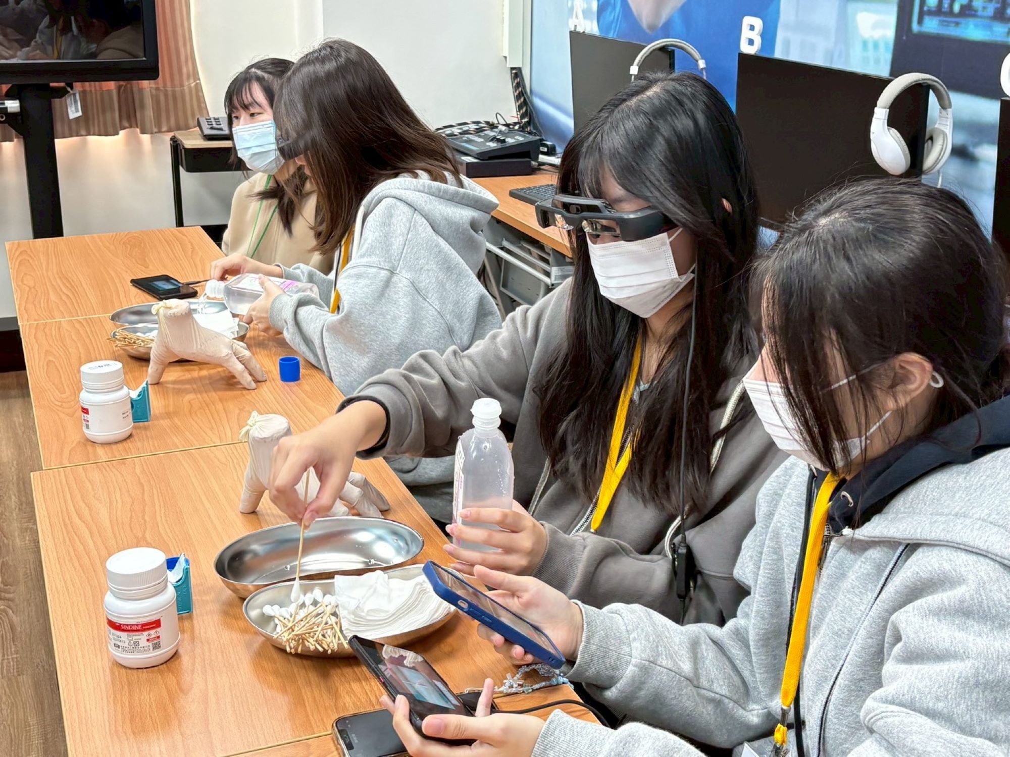 高中生佩戴 AR 眼鏡，運用擴增實境進行傷口換藥實作體驗。