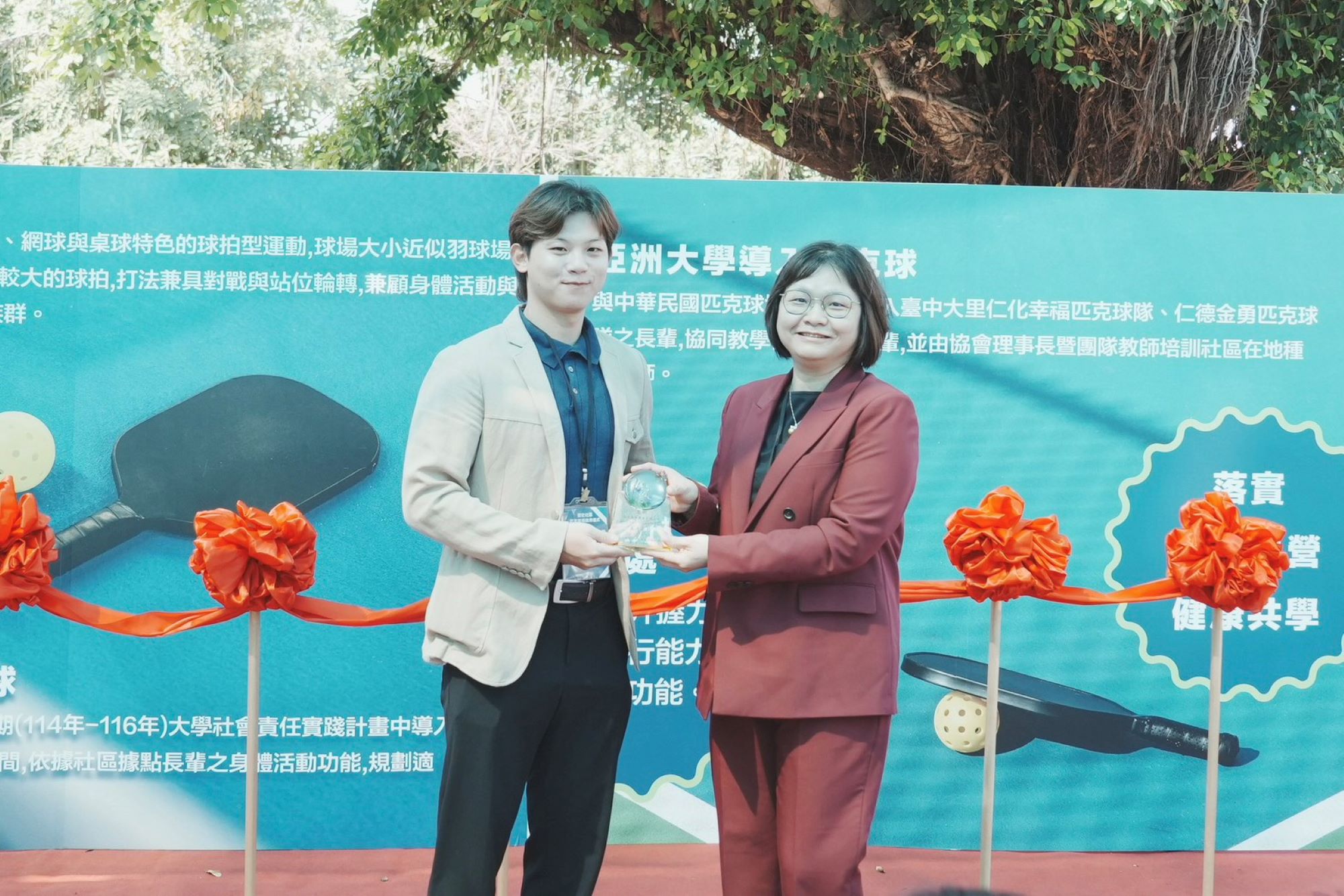 亞洲大學護理學院院長吳樺姍（右）致贈感謝獎牌予丞石運動事業有限公司主任簡克丞（左），感謝企業社會實踐支持社區發展。