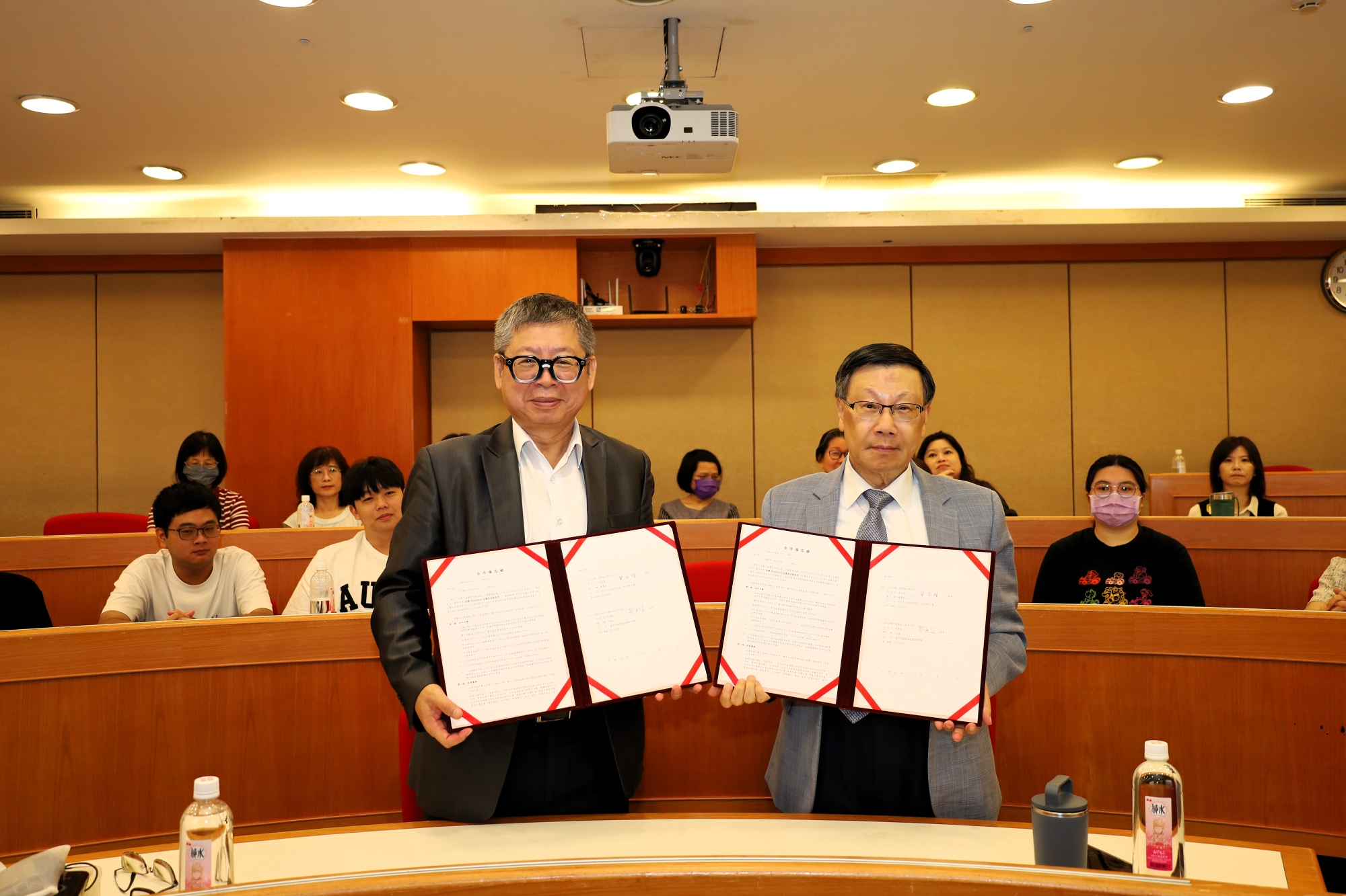 佐臻董事長梁文隆（左）與亞大校長蔡進發（右）共同展示產學合作備忘錄。